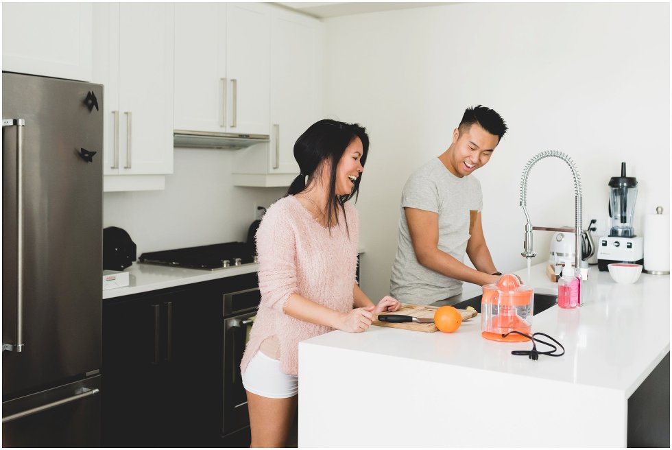 Couple making orange juice during their Toronto lifestyle maternity photos. 