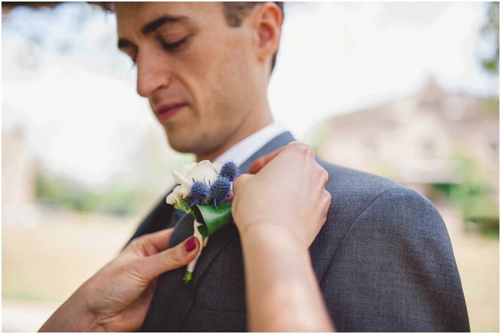 Groom getting his boutonniere put on