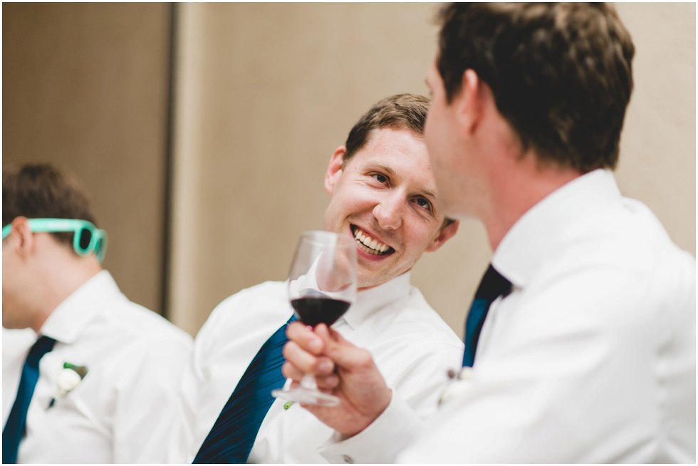 Candid moment of groomsmen chatting to a friend