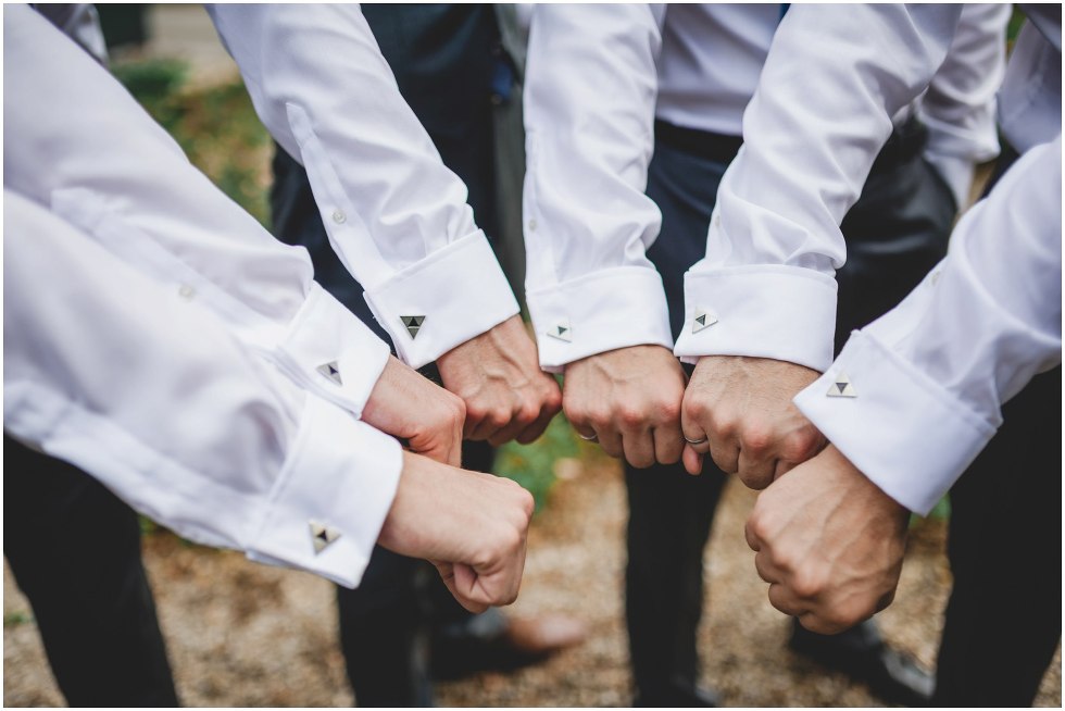 Groomsmen holding hands closely together to show cufflinks