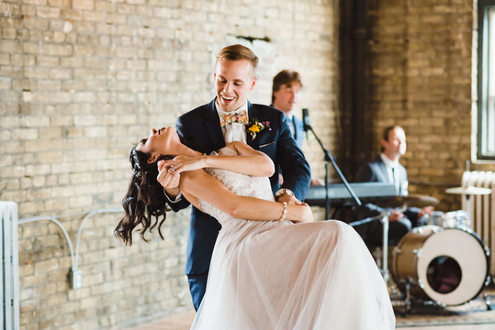 groom dipping bride as they dance in front wedding band at the Jam Factory Toronto wedding photography
