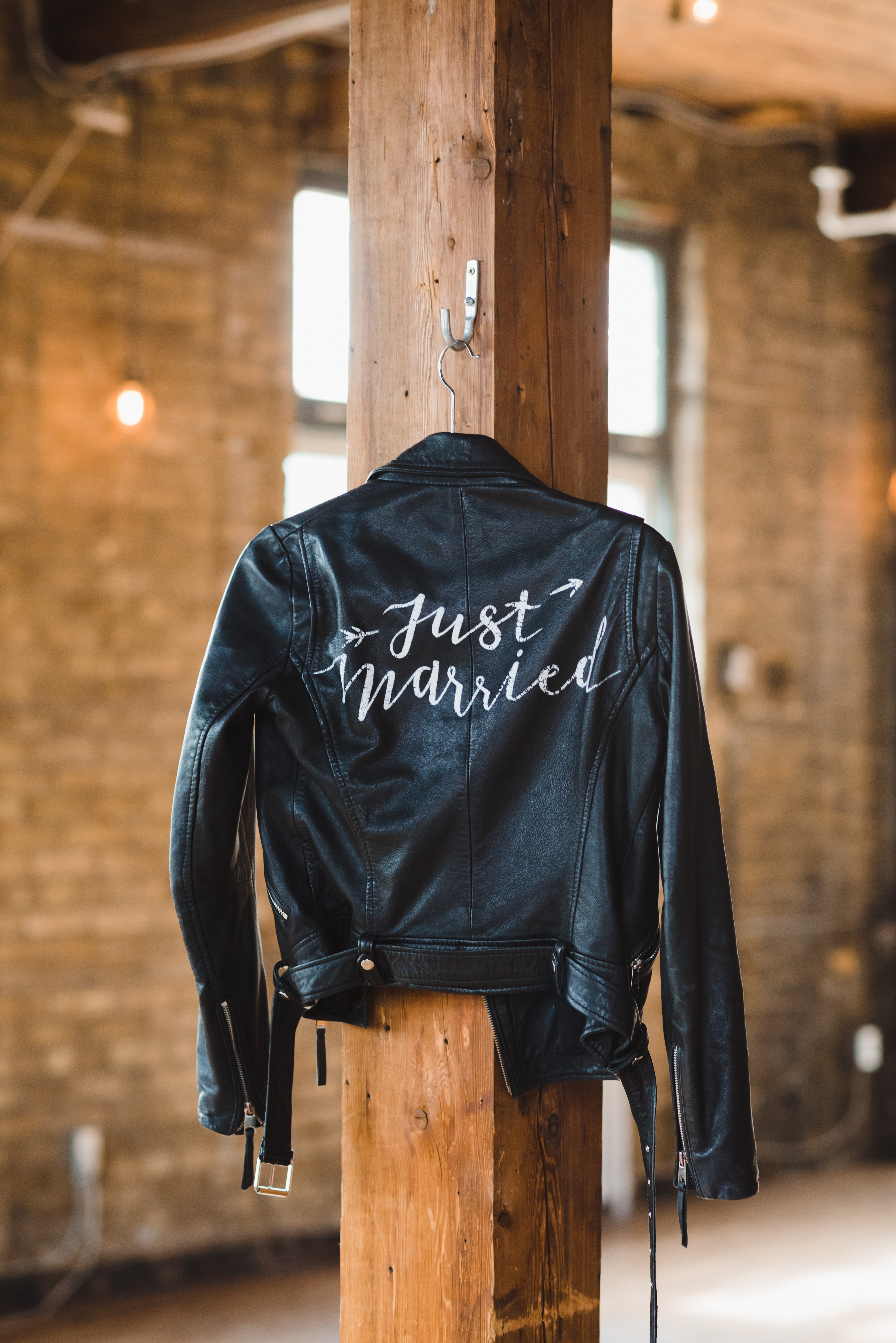 closeup of just married leather jacket hanging on wooden post at the Jam Factory Toronto wedding photography