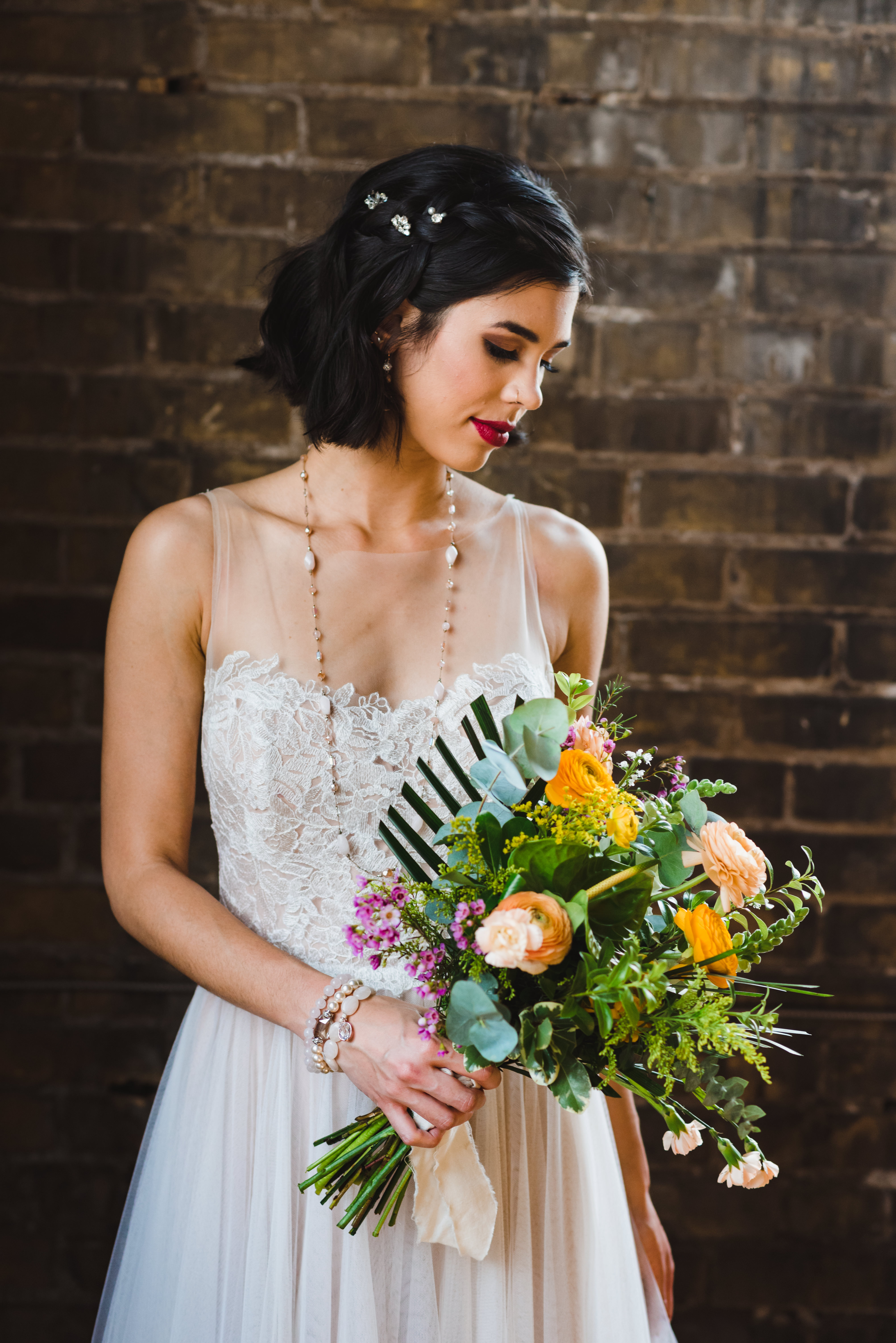 bride standing in front of old brick wall with bouquet at the Jam Factory Toronto wedding photography