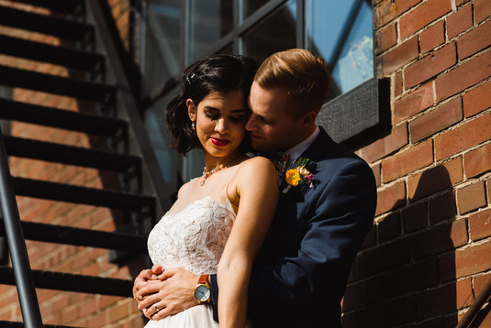 closeup of bride and groom in loving embrace on black fire escape staircase of the Jam Factory Toronto wedding photography