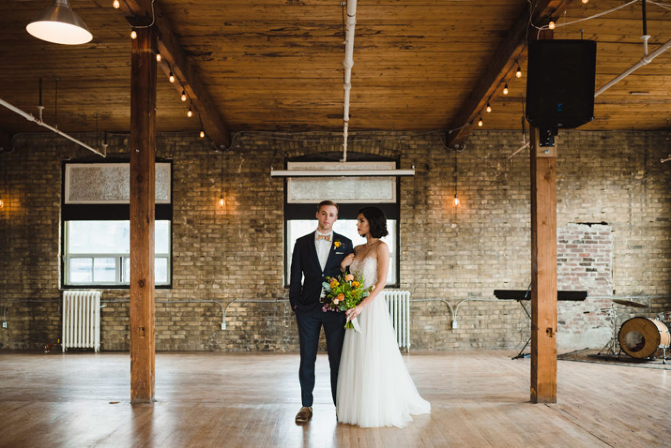 bride holding floral bouquet next to her groom at Jam Factory Toronto wedding photography