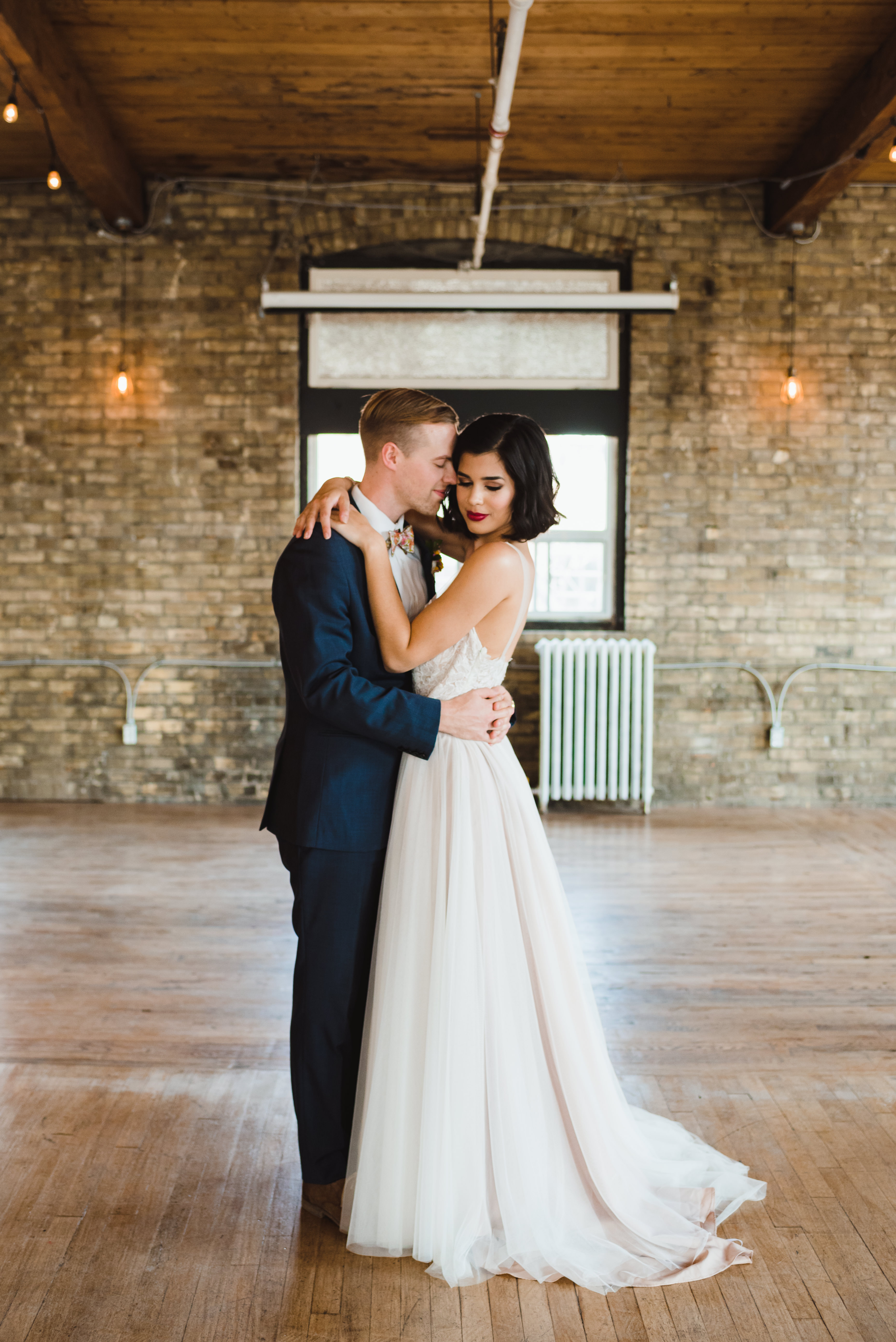 bride and groom loving embrace inside old brick building Toronto wedding photography