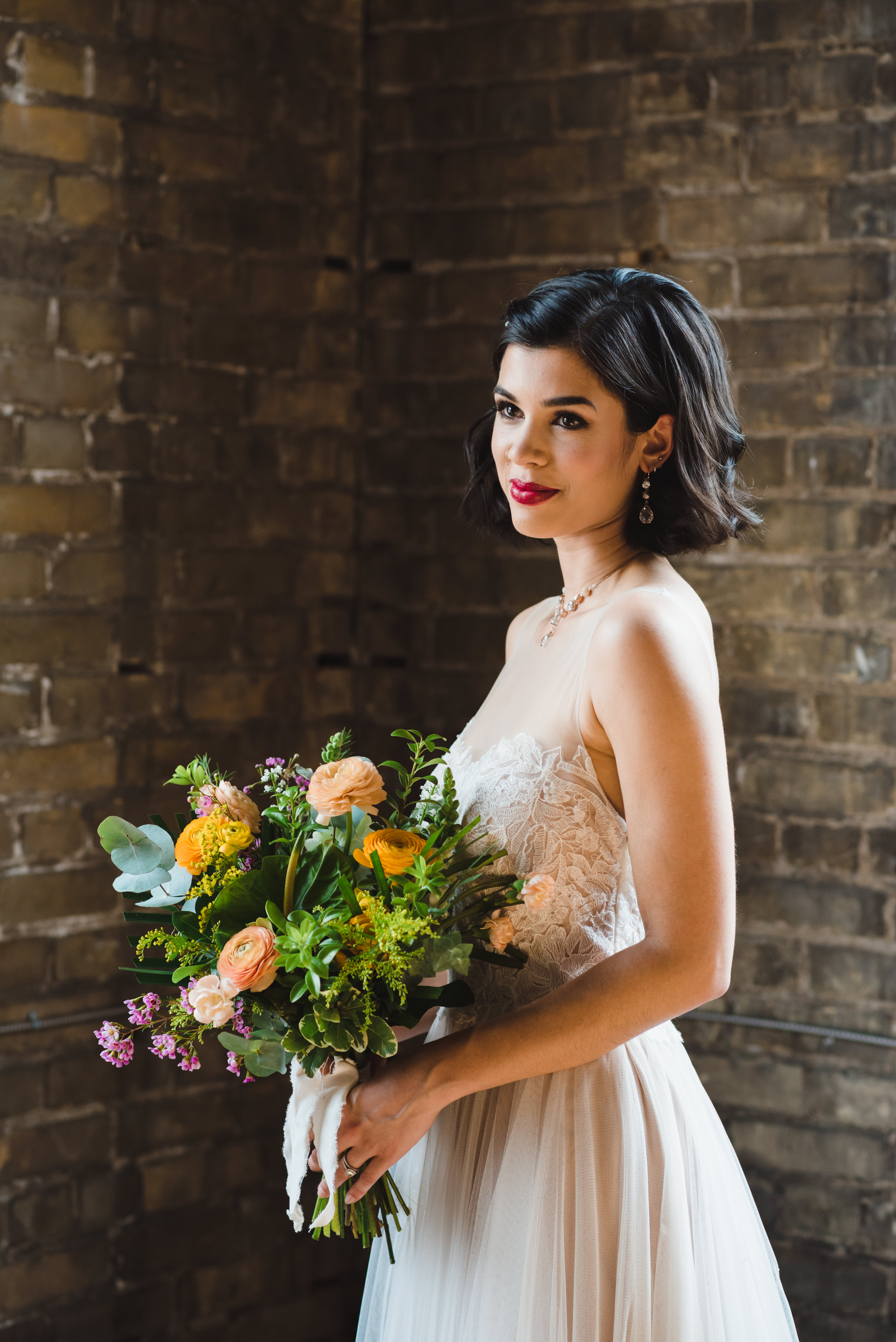 bride and her bouquet standing in front of old brick wall at the Jam Factory Toronto wedding photography