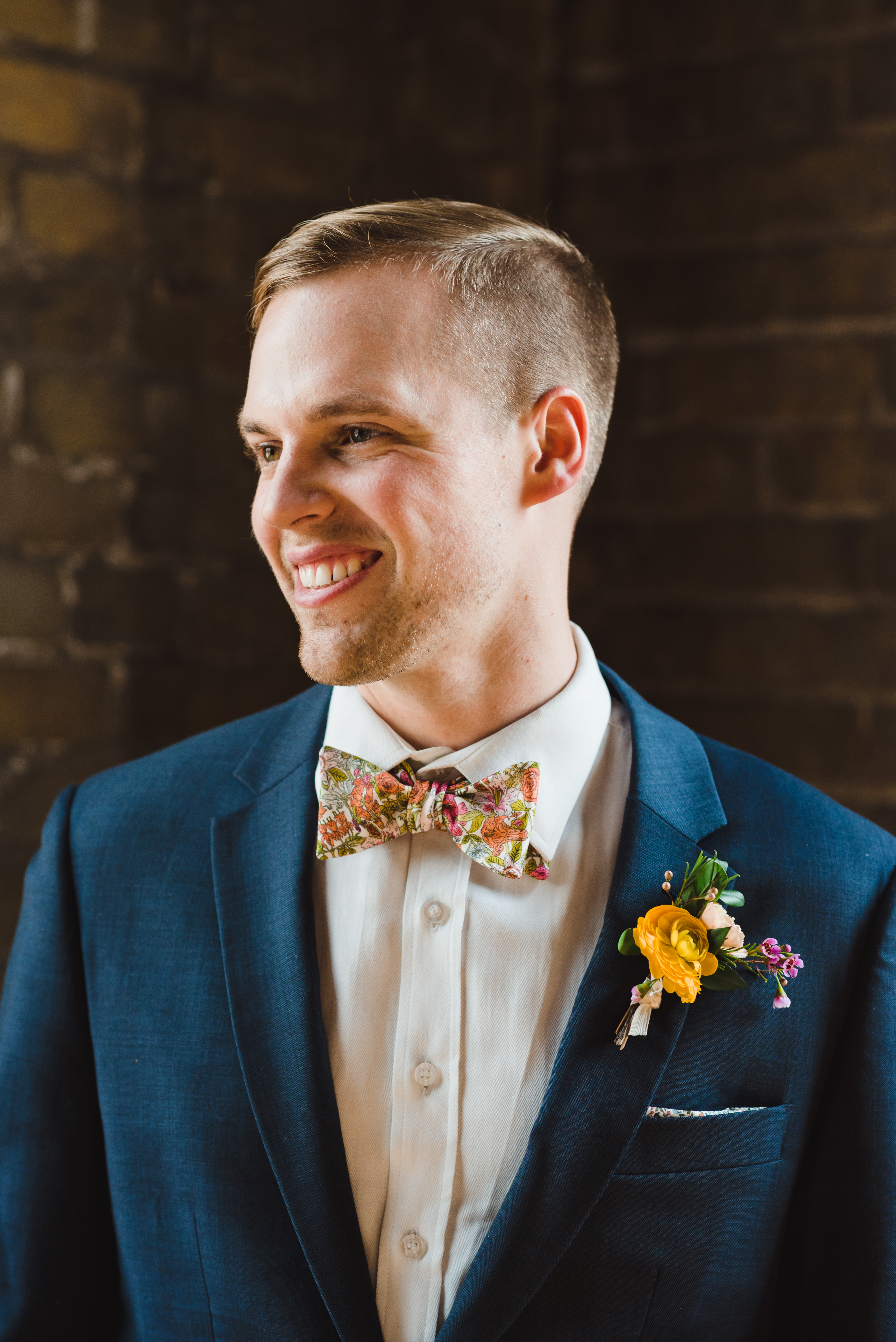 groom with floral bowtie and boutonniere smiling at the Jam Factory Toronto wedding photography