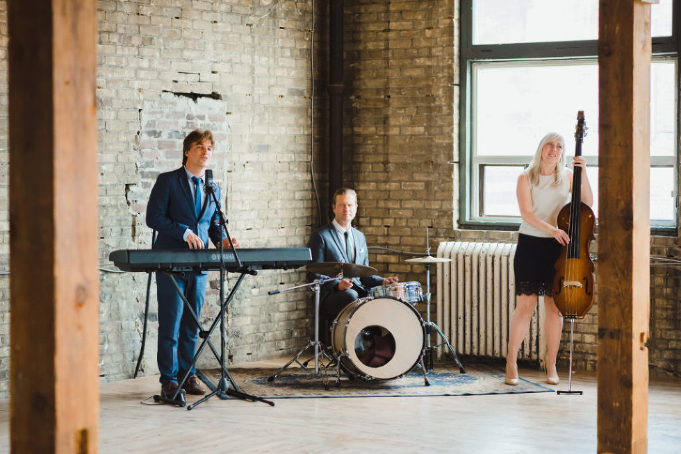 3 piece wedding band playing in the corner of the Jam Factory brick wall Toronto wedding photography 
