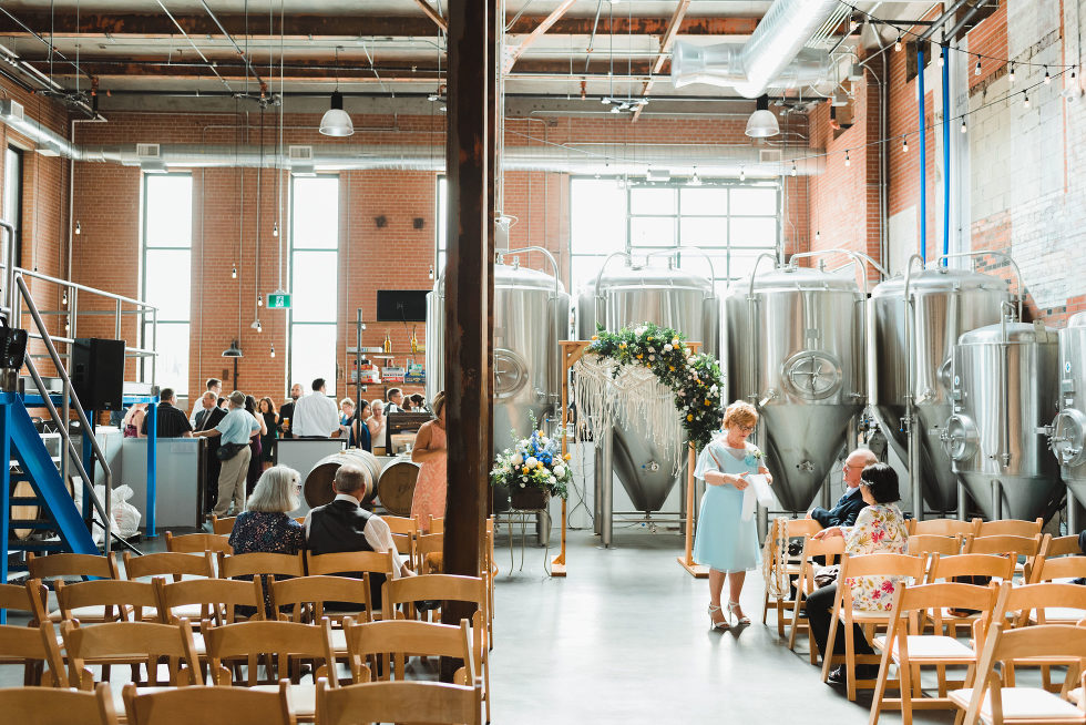 wedding ceremony set up in front of brewing tanks Toronto Junction Craft Brewing wedding