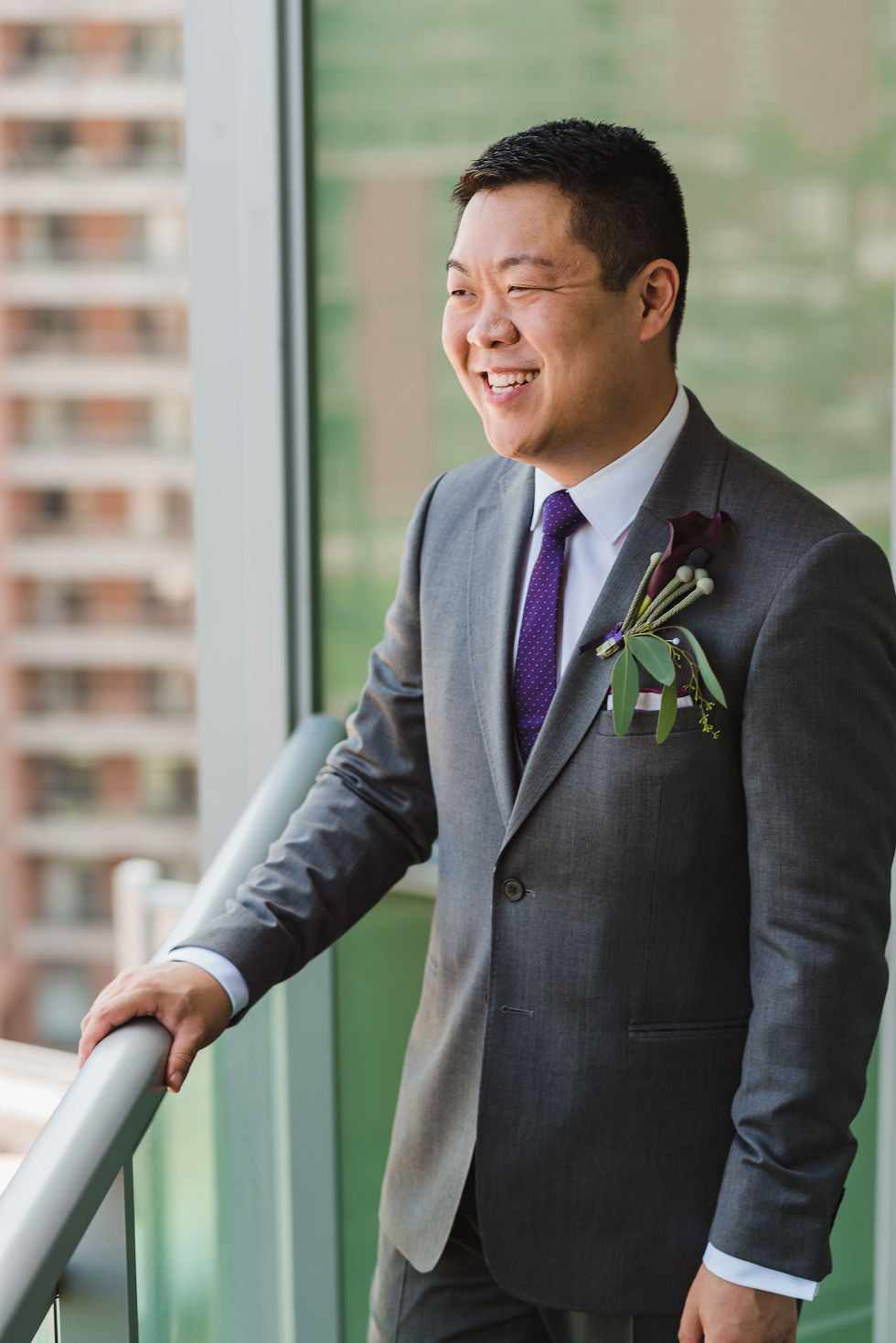 Groom laughing on a condo balcony before his Parisian inspired wedding at La Maquette in Toronto Ontario 